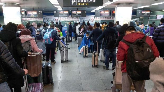 This photo taken on March 29, 2020 passengers wearing face masks, amid concerns of the COVID-19 coronavirus, queueing up to check-in before boarding flights at Yichang Sanxia Airport in Yichang in China's central Hubei province. - Airports in Hubei, except Wuhan Tianhe Airport, reopened for domestic flights on March 29 as travel restrictions have been loosened with official figures now routinely showing no new domestic infections. (Photo by STR / AFP) / China OUT