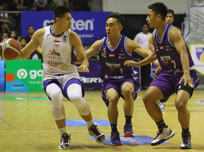 Pebasket Satria Muda Pertamina Avan Saputra (kiri) dihadang pebasket Amartha Hangtuah Sevly Rondonuwu (tengah) dan Lucky Abdi Pasondok, saat pertandingan seri keenam Indonesian Basketball League (IBL) Pertamax 2020 di DBL Arena, Surabaya, Jawa Timur, Sabtu (7/3/2020). Satria Muda Pertamina mengalahkan Amartha Hangtuah dengan skor akhir 83-79. ANTARA FOTO/Moch Asim/ama.