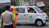 Mobil ambulans yang membawa jenazah PDP disterilkan dengan cara disemprot disinfektan.