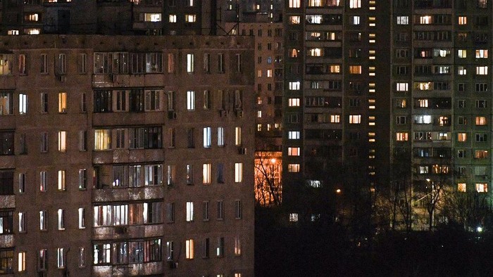 Residents stay in their apartments on the Moscow outskirts late on March 29, 2020. - All residents of Moscow will be under strict self-isolation rules beginning on March 30, 2020, the mayor said in the evening of March 29, as coronavirus cases climbed in the capital. Muscovites will only be allowed to leave their homes in the case of a medical emergency, to travel to work if necessary, and go to grocery stores or pharmacies, the capitals mayor Sergei Sobyanin said in a statement. (Photo by Kirill KUDRYAVTSEV / AFP)