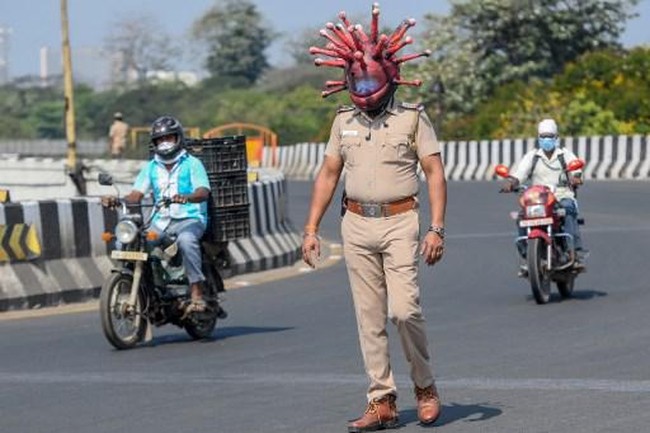Ada pemandangan yang tak biasa di jalanan Chennai, India, belakangan ini. Tampak seorang polisi berpatroli, lengkap dengan helm yang unik. Model helm tersebut menyerupai bentuk mikroskopik virus corona. (Foto: AFP/ARUN SANKAR)