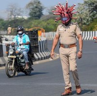 Ada pemandangan yang tak biasa di jalanan Chennai, India, belakangan ini. Tampak seorang polisi berpatroli, lengkap dengan helm yang unik. Model helm tersebut menyerupai bentuk mikroskopik virus corona. (Foto: AFP/ARUN SANKAR)