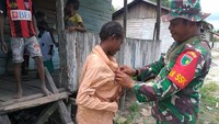 Personel Satgas TMMD Ke-107 Kodim 1707/Merauke yang dipimpin langsung oleh Danki Satgas TMMD Ke-107 Lettu Inf Antonius Kalambia membagikan baju layak pakai kepada warga Kampung Epem, Distrik Citak Mitak, Kabupaten Mappi, Selasa (31/3/2020). Pool/Kodim 1707/Merauke.