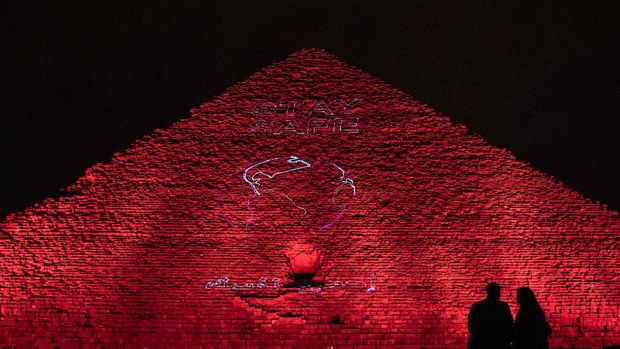 The Ministry of antiquities lights up the pyramids in an expression of support for health workers battling the coronavirus outbreak, Monday, March 30, 2020, in Giza, Egypt. (AP Photo/Nariman El-Mofty)