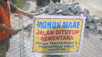 Warga memasang tanda penutupan akses perbatasan di jalan sirip Trenggalek-Tulungagung di Desa Malasan, Trenggalek, Jawa Timur, Senin (30/3/2020) kemarin. Upaya ini sesuai dengan kesepakatan Forkopimda Trenggalek guna menekan sebaran virus Corona di wilayahnya.