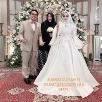Penampilan Eddies Adelia yang cantik saat akad nikah ini merupakan hasil pulasan makeup dari Ernie RedBerryWedding. Eddies tampil glamour dalam akad nikahnya yang kedua kali dengan mantan suaminya dalam balutan gaun pengantin putih yang dilengkapi dengan hijab, veil dan mahkota. Foto: Instagram Story @rinagunawan28