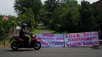 Sejumlah kampung di kawasan Pakem, Sleman, Yogyakarta juga telah lebih dulu menutup sejumlah akses masuk kampung dengan bambu yang diberi tulisan lockdown sebagai upaya antisipasi COVID-19. ANTARA FOTO/Andreas Fitri Atmoko.
