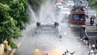 Kendaraan taktis Polresta Sidoarjo menyemprotkan cairan disinfektan di jalan protokol kawasan Waru, Sidoarjo, Jawa Timur, Selasa (31/3/2020). ANTARA FOTO/Umarul Faruq