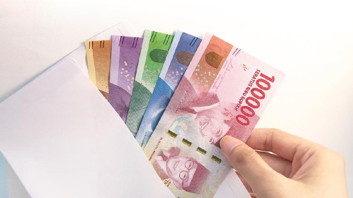 woman hand showing envelope and Indonesia rupiah money