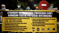 Plt Walikota Blitar Santoso (tengah) dan pejabat lainnya memasang spanduk kawasan tertib Pembatasan Sosial (Physical Distancing) di salah satu kawasan permukiman di Blitar, Jawa Timur. Selain mulai menerapkan kawasan Physical Distancing, Pemda setempat juga melakukan penutupan sejumlah jalan protokoler guna mencegah penyebaran COVID-19 di daerah itu. ANTARA FOTO/Irfan Anshori.