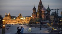 Pasangan menikmati cuaca hangat di jembatan dengan latar belakang Katedral St. Basil, kanan, dan Lapangan Merah yang hampir kosong setelah matahari terbenam di Moskow, Rusia, pada hari Sabtu, 28 Maret 2020 lalu. Industri pariwisata Eropa diprediksi juga menurun 16,2% dari 2019 ke 2020. AP Photo/Alexander Zemlianichenko Jr.