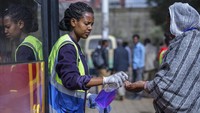 Seorang sukarelawan memberikan pembersih tangan kepada penumpang yang memasuki bus sebagai tindakan pencegahan terhadap penyebaran coronavirus baru di ibukota Addis Ababa, Ethiopia Walaupun termasuk dalam kategori negara miskin, hal tersebut tidak membuat warganya menghilangkan rasa kemanusiaan untuk selalu berbagi kepada sesama di tengah masa kritis wabah COVID-19. AP Photo/Mulugeta Ayene.