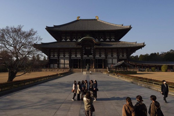 Turis berhenti sejenak untuk berfoto di depan aula utama kuil Todaiji di Nara, Jepang, 17 Maret 2020. Nara adalah salah satu kota Jepang pertama yang terkena COVID-19 pada akhir Januari, ketika seorang sopir bus wisata di kota dinyatakan positif terkena virus. AP Photo/Jae C. Hong. Turis berhenti sejenak untuk berfoto di depan aula utama kuil Todaiji di Nara, Jepang, 17 Maret 2020. Nara adalah salah satu kota Jepang pertama yang terkena COVID-19 pada akhir Januari, ketika seorang sopir bus wisata di kota dinyatakan positif terkena virus. AP Photo/Jae C. Hong.