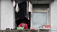 Ada yang menggantung cucian, anak-anak bermain, ada yang makan mie dengan santai, merokok dan lainnya. (dok Reuters)