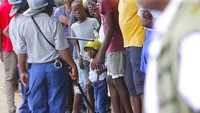 Polisi Zimbabwe berdiri bersama orang-orang dalam antrian mematuhi aturan untuk mencegah penyebaran virus corona, untuk memasuki supermarket di Harare, Zimbabwe, Senin (30/3/2020). Zimbabwe merupakan salah satu negara miskin yang berjuang melawan COVID-19  AP Photo/Tsvangirayi Mukwazhi.