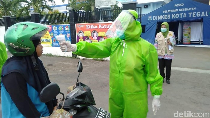 Momen Petugas Pakai APD Jaga Perbatasan Kota Tegal Isolasi wilayah di Kota Tegal, Jawa Tengah, untuk mencegah virus corona mulai dilaksanakan hari ini. Puluhan petugas dengan memakai APD berjaga di perbatasan.