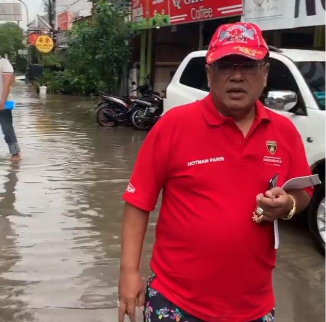 Gaya sederhana Hotman Paris dalam balutan kaos saat berjalan santuy di tengah banjir.  Foto: instagram