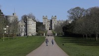 Warga menjaga jarak ketika mereka berjalan-jalan dengan anjing di Long Walk di Windsor Castle, Inggris Selasa, 24 Maret 2020. Saat ini Inggris masih dalam suasana lockdown untuk antisipasi COVID-19. AP Photo/Kirsty Wigglesworth.