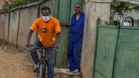 Seorang pria yang mengenakan masker mengendarai sepeda, di Antananarivo, Madagaskar, Senin (23/3/2020). Setelah mengkonfirmasi kasus pertamanya akan virus Corona, Semua sarana transportasi umum dihentikan, sekolah dan universitas juga ikut diliburkan selama sebulan. AP Photo/Alexander Joe.  
