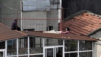 Mereka hanya bisa berinteraksi dengan tetangga melalui jendela atau atap. (dok Reuters)