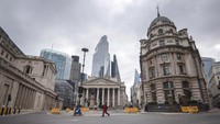Seorang wanita berjalan melalui persimpangan Bank yang sepi ketika Inggris terus mengunci untuk membantu mengekang penyebaran Coronavirus, di London, Senin 30 Maret 2020. Victoria Jones/PA via AP.