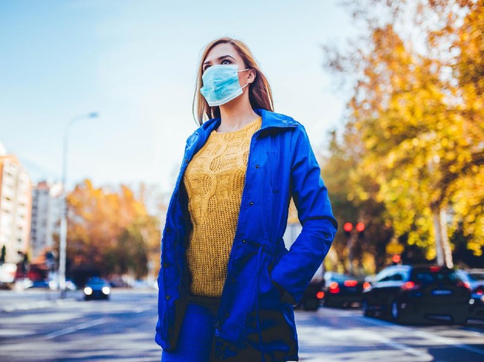 Young woman wearing face mask because of air pollution in the city