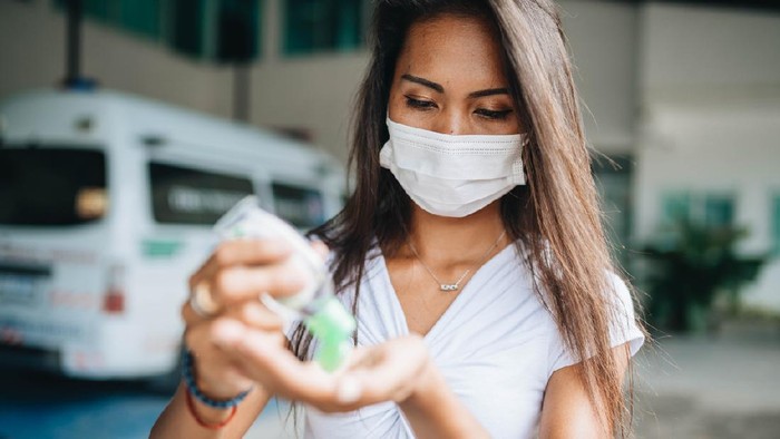 ilustrasi wanita pakai masker Young woman wearing face mask because of air pollution in the city