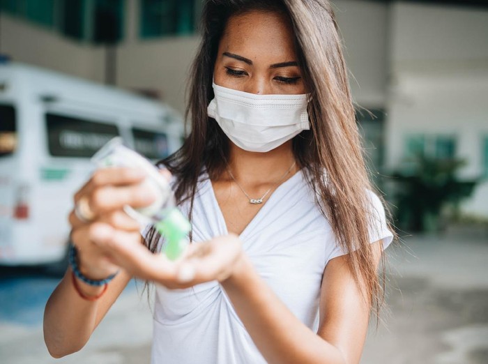 ilustrasi wanita pakai masker Young woman wearing face mask because of air pollution in the city