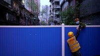 Ini foto saat tukang antar makanan memberikan paketnya meallui pagar pembatas. (Aly Song/Reuters)