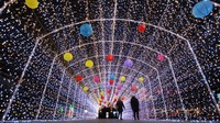 Pejalan kaki menikmati cahaya warna-warni dari lentera di Kota Yangzhou di Provinsi Jiangsu, China pada 5 Februari (Costfoto / Barcroft Media/Getty Images/CNN)