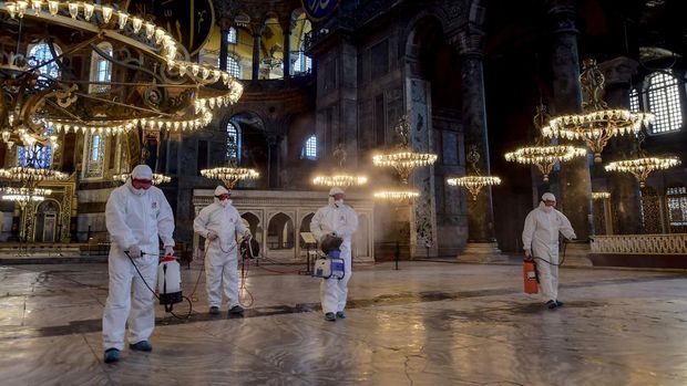Petugas membersihkan bagian dalam Hagia Sophia dengan disinfektan (Photo by Yasin AKGUL / AFP)