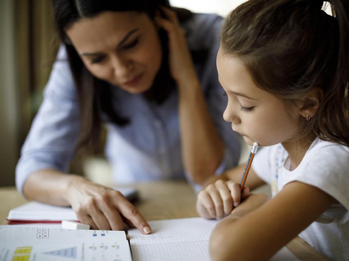 Mother helping daughter with homework