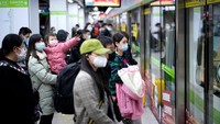 Kereta bawah tanah pun juga mulai beroperasi. ORang-orang masih mengenakan masker saat di stasiun. (Aly Song/Reuters)
