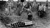 Para tentara berduka atas gugurnya salah satu prajurit Divisi Marinir I AS, PFC Michael Fenton (19) dalam pendaratan di Okinawa. Seseorang yang berlutut di samping jenazah Michael Fenton adalah ayahnya, Kolonel Marinir Francis Fenton.