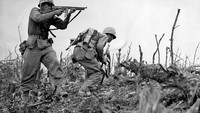 Seorang Marinir AS menembakkan  senapan mesinnya ke arah penembak jitu Jepang di Wana Ridge sebelum kota Shuri di Okinawa Selatan. 
