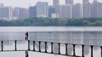 Terlihat sepasang sijoli menikmati waktu di Ewas Lake di Wuhan. Mereka berpelukan namun tetap keduanya memakai masker. (Aly Song/Reuters)
