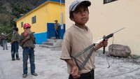 Begitulah fakta yang menggembaran dunia, dimana anak-anak usia sekolah dilatih memegang senjata di desa mereka. (Alexandre Meneghini/Reuters)