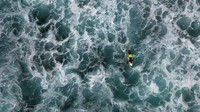 Seorang surfer melintasi perairan Pantai Praia de Cruz di Sal Rei, yang terletak di pantai barat laut Boa Vista, Tanjung Verde (Ina Fassbender/AFP/Getty Images/CNN)