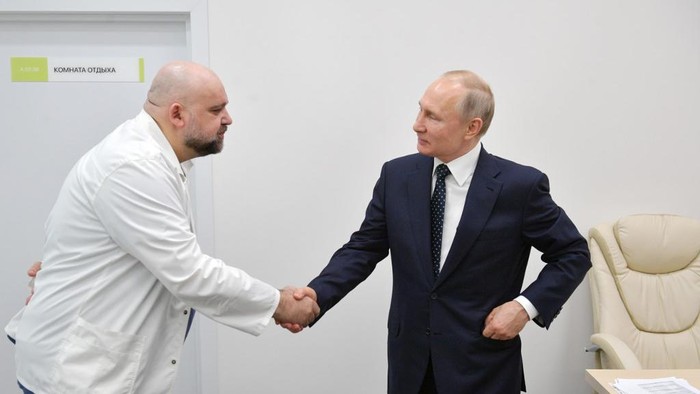 A picture taken on March 24, 2020 shows Russian President Vladimir Putin (R) shaking hands with the head of Moscows new hospital treating coronavirus (COVID-19) patients Denis Protsenko during his visit to Kommunarka hospital in Moscow. - The head of Moscows main coronavirus hospital who met with President Vladimir Putin a week ago has tested positive to the COVID-19, he said on March 31, as the Kremlin announced the Russian leaders health was fine. Denis Protsenko met with the Russian leader who inspected the Kommunarka hospital while wearing a bright yellow hazmat suit. But the 67-year-old Putin was also seen talking to Protsenko without any protective gear. (Photo by Alexey DRUZHININ / SPUTNIK / AFP)