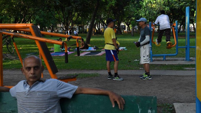 People exercise early morning in Lumpini park in central Bangkok on April 23, 2018. (Photo by LILLIAN SUWANRUMPHA / AFP)