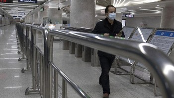 Warga melintas di salah satu subway di kota Wuhan, China. sebelum naik subway mereka harus mempersiapkan aplikasi untuk mendapatkan kode kesehatan. (AP Photo/Ng Han Guan)