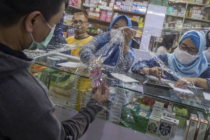 Jaga Jarak, Kegiatan Jual Beli di Apotel Dibatasi Plastik Kasus corona di Indonesia kini sebanyak 1790 kasus, segala bentuk pencegahan dimaksimalkan seperti berjualan dari balik plastik seperti ini.