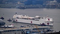 Kapal rumah sakit Angkatan Laut USNS Comfort bergerak di sepanjang Sungai Hudson sebelum berlabuh di New York, Senin, 30 Maret 2020. Kapal ini memiliki 1.000 tempat tidur dan 12 ruang operasi yang dapat berdiri dan beroperasi dalam 24 jam setelah kedatangannya pada Senin pagi. Diharapkan untuk mendukung sistem perawatan kesehatan yang terintegrasi dan untuk sementara waktu rumah sakit ini untuk merawat orang dengan COVID-19. AP Photo/Craig Ruttle.  