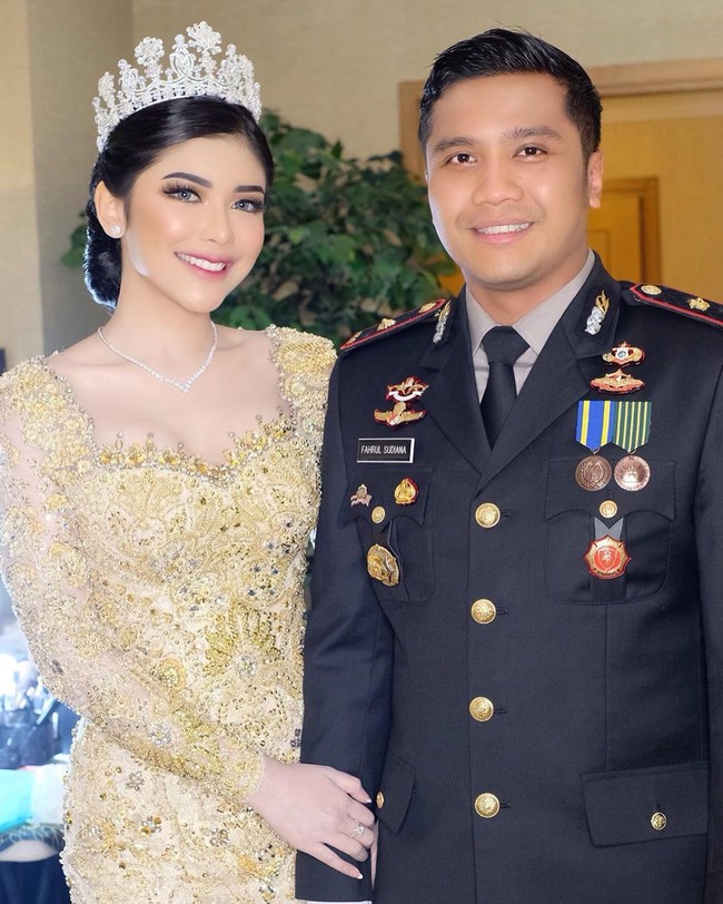 Saat resepsi pernikahan, Rica dan Fahrul Sudiana memilih gaya busana internasional. Fahrul sendiri memakai seragam kepolisiannya dan Rica mengenakan gaun emas rancangan Asky Febrianti. Foto: Instagram @bennusorumba