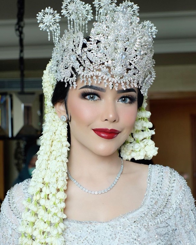 Lipstik merah dengan riasan mata yang bold dari makeup artist Bennu Sorumba membuat Rica Andriani tampil manglingi di hari pernikahannya dengan Kompol Fahrul Sudiana. Akad nikah Fahrul dan Rica digelar pada 21 Maret 2020 di Hotel Mulia, Senayan. Foto: Instagram @bennusorumba
