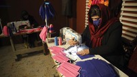 Seorang wanita menjahit masker kain di bekas pabrik pakaian di Kabul, Afghanistan. AP Photo/Rahmat Gul.