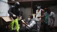 Moscoso memberikan makanan kepada seorang penyandang disabilitas.