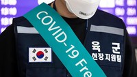 Seorang tentara Korea Selatan mengenakan spanduk bertuliskan COVID-19 Free dan topeng pelindung berada pada titik pemeriksaan suhu di Bandara Internasional Incheon di Incheon, Korea Selatan. Korea Selatan sempat menjadi salah satu negara dengan jumlah kasus virus corona tertinggi setelah China. Namun begitu, tingkat kematian akibat COVID-19 di Negeri Ginseng terhitung rendah yakni sebesar 1,65 persen dari total 9.786 kasus. SeongJoon Cho/Bloomberg via Getty Images.
