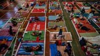 Para pengungsi beristirahat di tikar yang diberi jarak untuk menjaga jarak sosial ketika mereka menempati gimnasium yang telah diubah menjadi tempat penampungan.