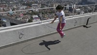 Ada juga seorang gadis belia yang berjemur di atap rumahnya sambil bermain. Berjemur juga dapat dilakukan di atap rumah dan sambil berolahraga seperti seorang anak di Mexico ini. AP Photo/Marco UGarte